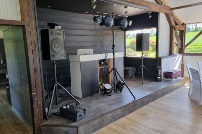 Un cheval de trait tire une calèche avec un conducteur et un passager, sur un chemin en milieu rural.