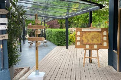 Un cheval de trait tire une calèche avec un conducteur et un passager, sur un chemin en milieu rural.
