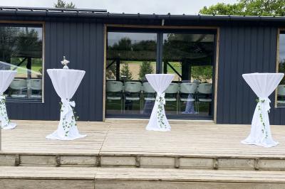 Un cheval de trait tire une calèche avec un conducteur et un passager, sur un chemin en milieu rural.