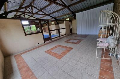 Un cheval de trait tire une calèche avec un conducteur et un passager, sur un chemin en milieu rural.