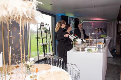 Un cheval de trait tire une calèche avec un conducteur et un passager, sur un chemin en milieu rural.