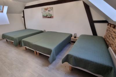 Chambre lumineuse avec un lit double, couvre-lit rose, deux tables de chevet et une décoration murale.