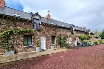 Chambre lumineuse avec un lit double, couvre-lit rose, deux tables de chevet et une décoration murale.