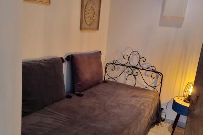 Chambre lumineuse avec un lit double, couvre-lit rose, deux tables de chevet et une décoration murale.