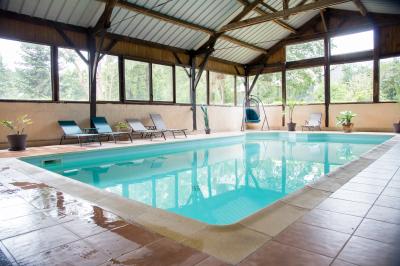 Chambre lumineuse avec un lit double, couvre-lit rose, deux tables de chevet et une décoration murale.