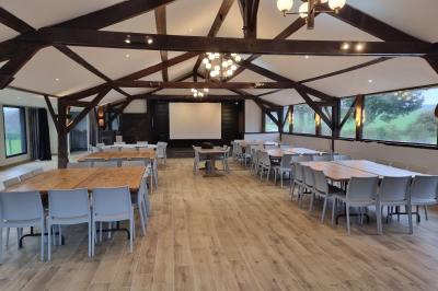 Chambre lumineuse avec un lit double, couvre-lit rose, deux tables de chevet et une décoration murale.