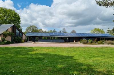 Chambre lumineuse avec un lit double, couvre-lit rose, deux tables de chevet et une décoration murale.