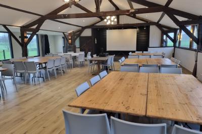 Chambre lumineuse avec un lit double, couvre-lit rose, deux tables de chevet et une décoration murale.