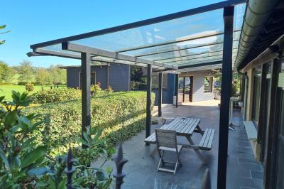Chambre lumineuse avec un lit double, couvre-lit rose, deux tables de chevet et une décoration murale.