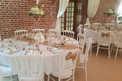 Lit avec coussins colorés et décoration murale en macramé dans une chambre lumineuse.