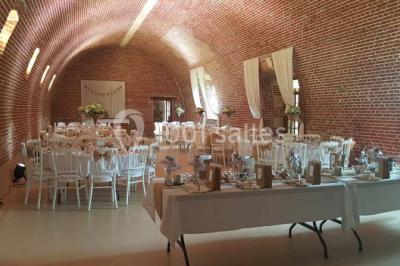 Lit avec coussins colorés et décoration murale en macramé dans une chambre lumineuse.