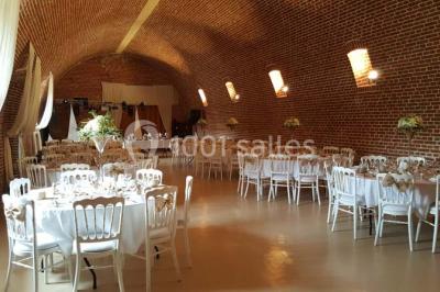 Lit avec coussins colorés et décoration murale en macramé dans une chambre lumineuse.