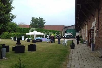 Lit avec coussins colorés et décoration murale en macramé dans une chambre lumineuse.