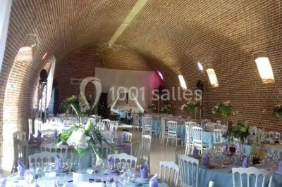 Lit avec coussins colorés et décoration murale en macramé dans une chambre lumineuse.