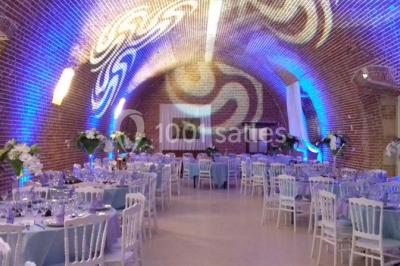 Lit avec coussins colorés et décoration murale en macramé dans une chambre lumineuse.