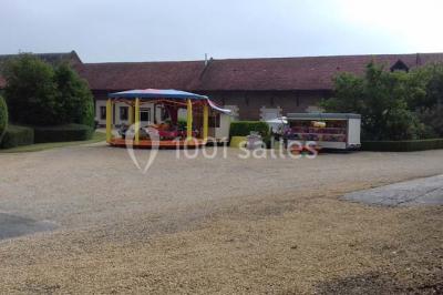 Lit avec coussins colorés et décoration murale en macramé dans une chambre lumineuse.