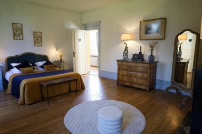 Lit avec coussins colorés et décoration murale en macramé dans une chambre lumineuse.