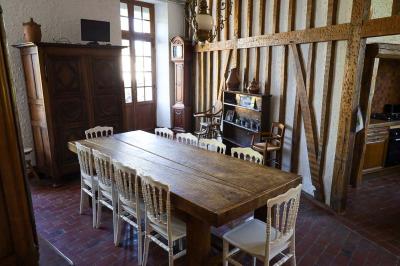 Lit avec coussins colorés et décoration murale en macramé dans une chambre lumineuse.