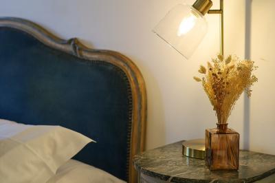 Lit avec coussins colorés et décoration murale en macramé dans une chambre lumineuse.