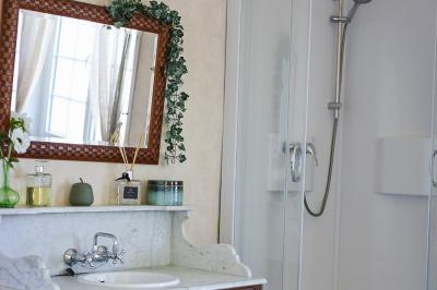 Lit avec coussins colorés et décoration murale en macramé dans une chambre lumineuse.