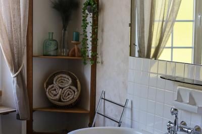 Lit avec coussins colorés et décoration murale en macramé dans une chambre lumineuse.