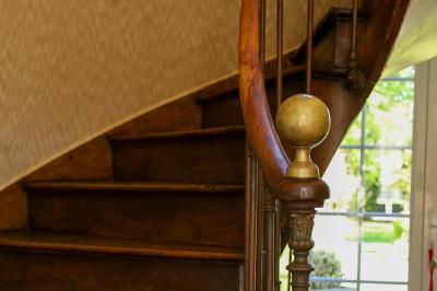 Lit avec coussins colorés et décoration murale en macramé dans une chambre lumineuse.