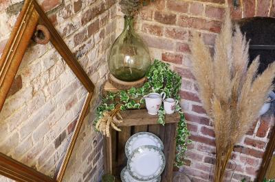 Lit avec coussins colorés et décoration murale en macramé dans une chambre lumineuse.