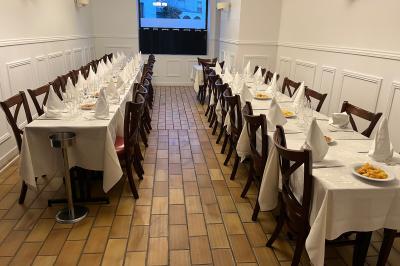 Salle de réception décorée avec des tables dressées, un tapis rouge central et des rideaux rouges et dorés.