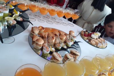 Plateaux de fruits frais composés de bananes, ananas, raisins, fraises, oranges et pastèques, décorés avec des couteaux.