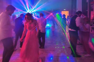 Château illuminé de nuit avec des murs en pierre, entouré d'arbres et d'une chaîne métallique au premier plan.