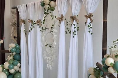 Château illuminé de nuit avec des murs en pierre, entouré d'arbres et d'une chaîne métallique au premier plan.