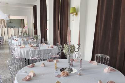 Château illuminé de nuit avec des murs en pierre, entouré d'arbres et d'une chaîne métallique au premier plan.