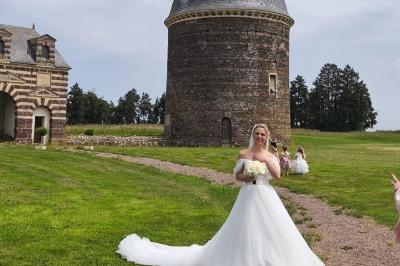 Château illuminé de nuit avec des murs en pierre, entouré d'arbres et d'une chaîne métallique au premier plan.