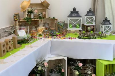 Bâtiment à façade rouge et blanche avec une pergola blanche et un banc en pierre dans un jardin verdoyant.