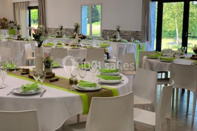 Bâtiment à façade rouge et blanche avec une pergola blanche et un banc en pierre dans un jardin verdoyant.
