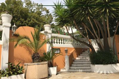 Buffet en extérieur avec tables garnies de plats, invités debout discutant sous des parasols blancs.