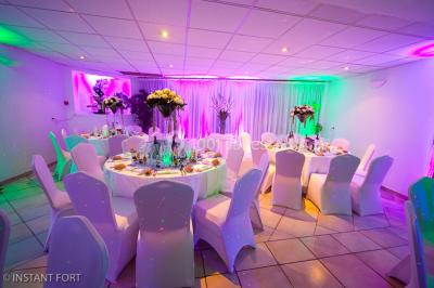 Buffet en extérieur avec tables garnies de plats, invités debout discutant sous des parasols blancs.