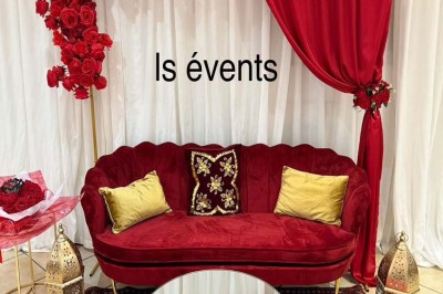 Buffet en extérieur avec tables garnies de plats, invités debout discutant sous des parasols blancs.