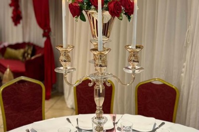 Buffet en extérieur avec tables garnies de plats, invités debout discutant sous des parasols blancs.