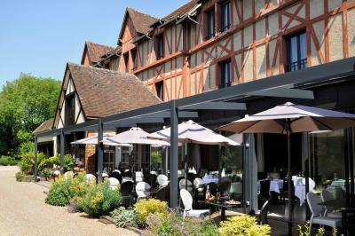 Chambre avec lit double, deux fauteuils rayés, table basse blanche et décoration murale dans un intérieur moderne.