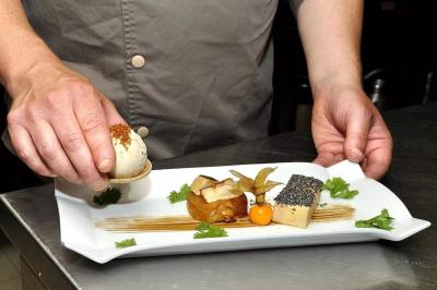 Chambre avec lit double, deux fauteuils rayés, table basse blanche et décoration murale dans un intérieur moderne.