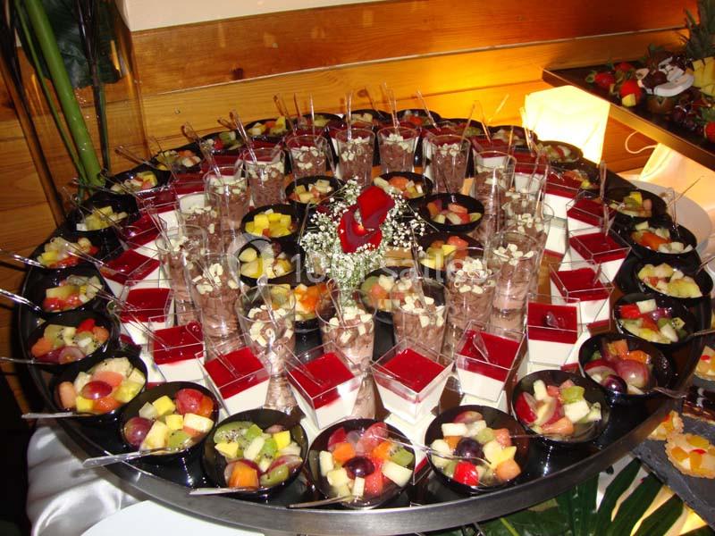 Plateau circulaire garni de verrines variées contenant des desserts colorés, fruits frais, gelées et mousses.