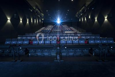Façade d'un cinéma Gaumont avec des affiches IMAX, un parvis vide et deux lampadaires au premier plan.