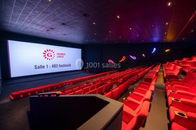 Façade d'un cinéma Gaumont avec des affiches IMAX, un parvis vide et deux lampadaires au premier plan.