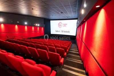 Façade d'un cinéma Gaumont avec des affiches IMAX, un parvis vide et deux lampadaires au premier plan.