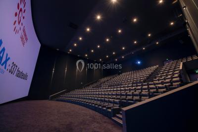 Façade d'un cinéma Gaumont avec des affiches IMAX, un parvis vide et deux lampadaires au premier plan.