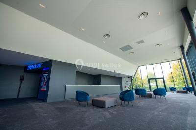 Façade d'un cinéma Gaumont avec des affiches IMAX, un parvis vide et deux lampadaires au premier plan.