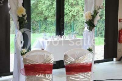 Assiette d'os à moelle avec pain grillé, verre de vin rouge et sel, posés sur une table avec une bouteille en arrière-plan.