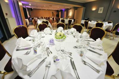 Assiette d'os à moelle avec pain grillé, verre de vin rouge et sel, posés sur une table avec une bouteille en arrière-plan.