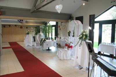 Assiette d'os à moelle avec pain grillé, verre de vin rouge et sel, posés sur une table avec une bouteille en arrière-plan.